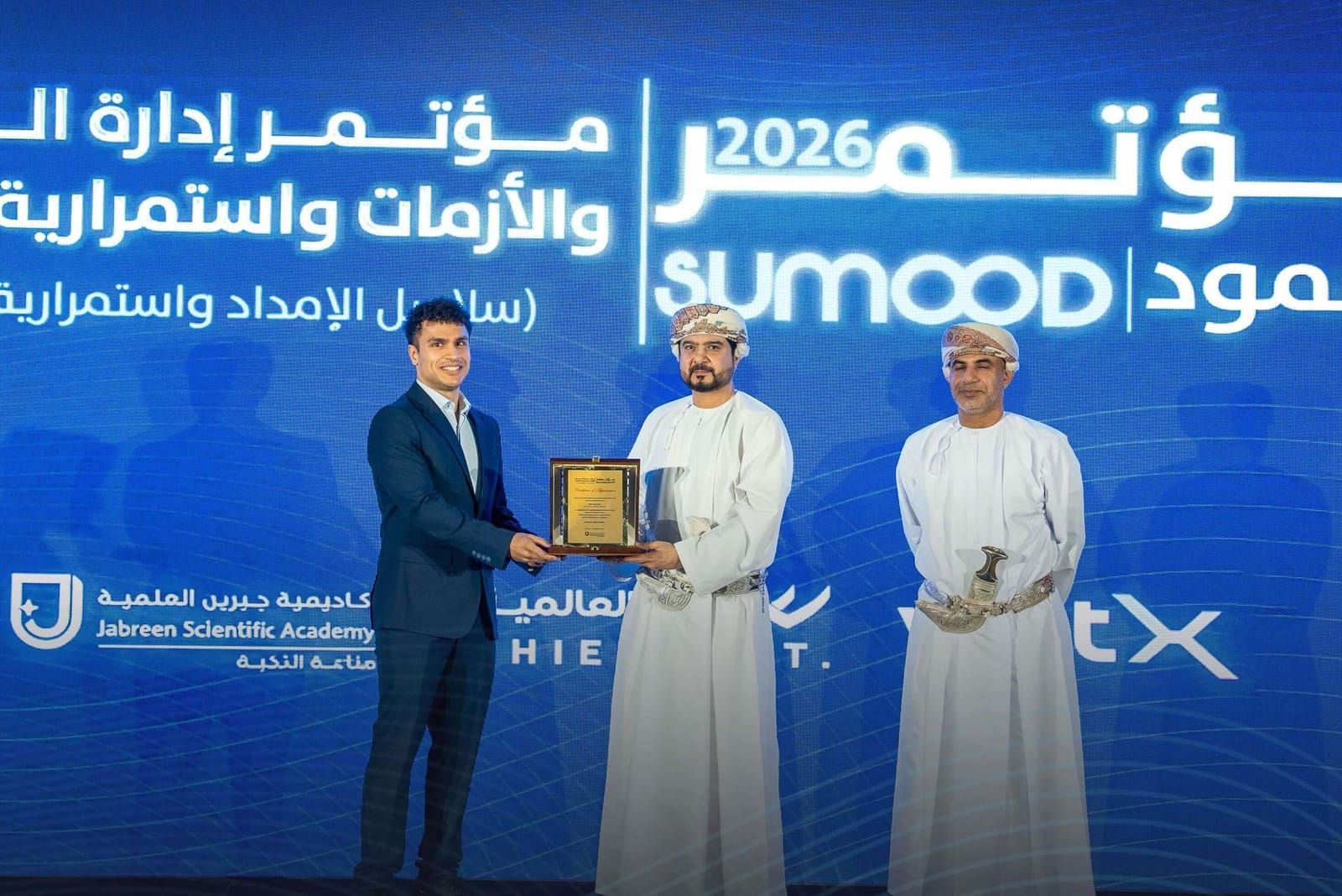 Nizar Ntarouis receives a certificate of appreciation on the Sumood 2026 stage in Muscat